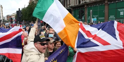 Tanto o Union Jacks quanto os tricolores irlandeses foram levados por manifestantes anti-imigração no centro da cidade de Belfast, que entraram em conflito com manifestantes anti-racismo. Fogos de artifício e outros mísseis foram jogados. Foto de Declan Roughan / Press Eye-Pacemaker Press Eye