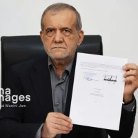O presidente iraniano, Masoud Pezeshkian, mostrando o memorando de entendimento com os EUA após assiná-lo • Ahmad Moeini Jam/IRNA