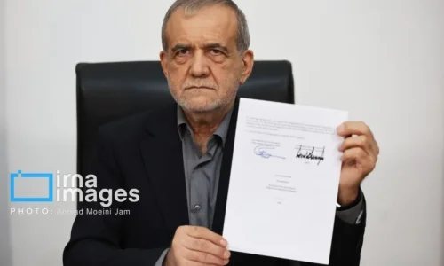 O presidente iraniano, Masoud Pezeshkian, mostrando o memorando de entendimento com os EUA após assiná-lo • Ahmad Moeini Jam/IRNA